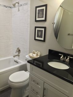 a bathroom with a sink, toilet and bathtub next to a mirror on the wall