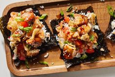 four pieces of sushi with various toppings on a wooden tray, ready to be eaten