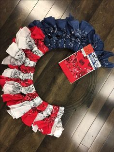 a wreath made out of red, white and blue ruffles sitting on top of a wooden floor