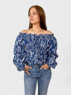 Keep up with the latest trends in the Phoebe Top - the perfect balance of style and comfort! This off shoulder top features playful prints and an adjustable waist tie for a flattering peplum style. You'll be turning heads and feeling fabulous any time you wear it. 100% Cotton Hand Wash Cold Off-shoulder Top With Smocked Bodice For Fall, Flowy Smocked Top For Day Out, Casual Off-shoulder Smocked Top For Summer, Casual Off-shoulder Smocked Top For Spring, Casual Off-shoulder Peasant Top, Trendy Spring Vacation Off-shoulder Top, Chic Off-shoulder Peasant Top For Spring, Trendy Spring Off-shoulder Top For Vacation, Blue Long Sleeve Off-shoulder Top For Spring