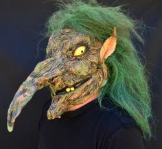 a man with green hair and an ugly mask