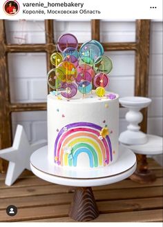 there is a white cake with rainbow decorations on it