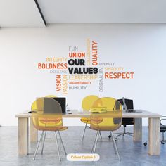 a table with yellow chairs in front of a wall that has words written on it