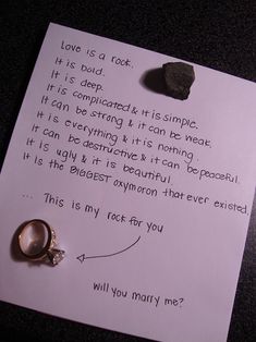 a piece of paper that has some kind of ring on it, and a note with the words love is a rock