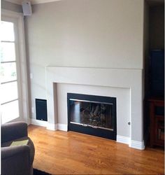 an empty living room with a fireplace and television