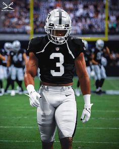 a football player walking on the field with his hands in his pockets and wearing a helmet