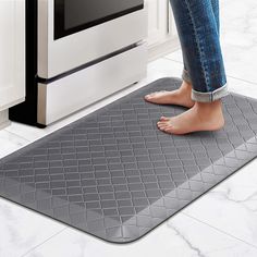 a person standing on a mat in front of an oven with their feet propped up