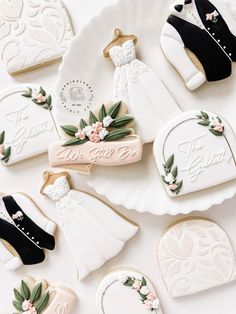 wedding cookies are arranged on a plate with bride's dress and groom's shoes