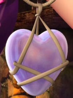 a heart shaped object hanging from a string