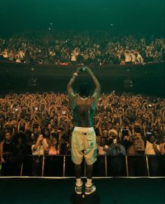 a man standing on top of a stage in front of a crowd