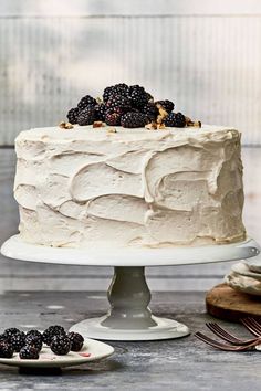 a white cake sitting on top of a table next to other desserts and utensils