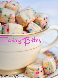 a white cup filled with colorful sprinkles on top of a plate