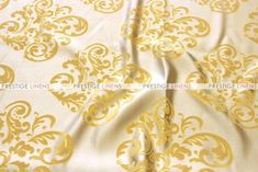 a white and gold fabric with an ornate design on it's side, as well as