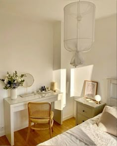 a bedroom with a bed, desk and chair in it next to a lamp hanging from the ceiling