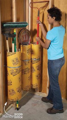 a woman holding a racquet in her hand next to some yellow rolls of construction material