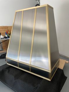 a large metal object sitting on top of a piece of black material in a room