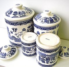 blue and white porcelain canisters with lids are on the shelf next to each other