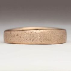 a close up of a gold ring on a white surface