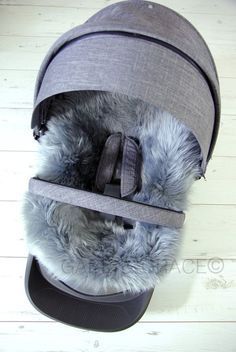 a gray hat with fur inside on top of a wooden floor