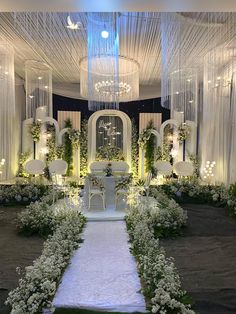 a wedding ceremony with white flowers and chandeliers