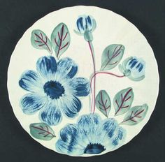 a blue and white plate with flowers painted on the front, sitting on a black surface