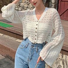 a woman is posing for the camera while wearing jeans and a white top with crochet