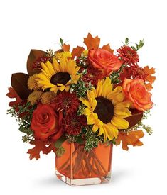 an orange vase filled with sunflowers, roses and other flowers on a white background