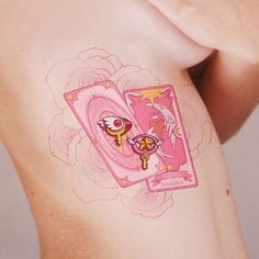 a woman's stomach with tattoos on it and two cards in the shape of an angel