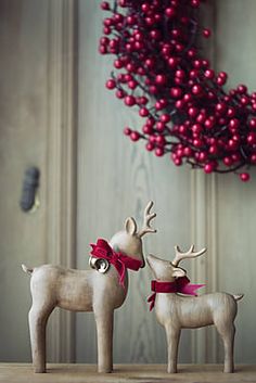 two wooden reindeer figurines standing next to each other on top of a table