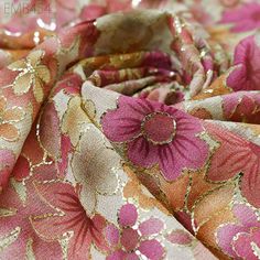 a close up view of a pink and gold flowered fabric with sequins