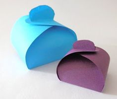 two pieces of blue and purple paper sitting next to each other on a white surface