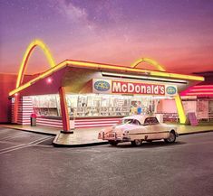 an old car is parked in front of a mcdonald's fast food restaurant at night