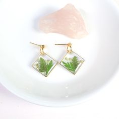 Fern leaf earrings, handmade resin jewelry. Pressed flower nature dangles in silver or gold. Real green ferns, leaves, and seeds are set in resin in these diamond-shaped, square dangles. Set on a ball stud, perfect as a nature lover gift, or for wildflower weddings. Dainty and lightweight.  Dimensions: From stud to bottom of earring - 1.25 inches Width - just over 3/4 inches Ball studs are hypoallergenic and each pair comes with a steel and silicone backing for tarnish-resistance and sensitive l Flower Resin Jewelry, Botanical Jewelry, Square Diamond, Wildflower Wedding, Geometric Jewelry, Gifts For Nature Lovers, Leaf Earrings, Pressed Flowers, Resin Jewelry