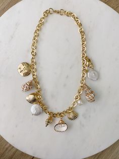 Seashells By The Seashore Necklace – Carolina Benoit Seashell Gold Jewelry, Summer Gold Necklace, Seashell Charm Bracelet, Trendy Beach Jewelry, Chunky Gold Charm Necklace, Summer Charm Necklace, Sea Shell Jewelry Aesthetic, Gold Summer Jewelry, Shell Neckless