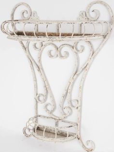 an old white iron shelf with ornate designs