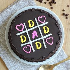 a chocolate cake with pink and yellow icing that says'dad's day '