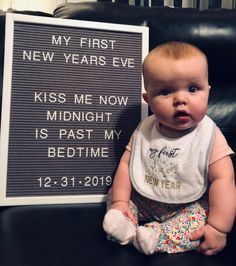 a baby sitting next to a sign that says my first new years eve kiss me now midnight is past my bedtime