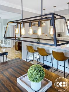 an open kitchen and dining room with bar stools in front of the counter top