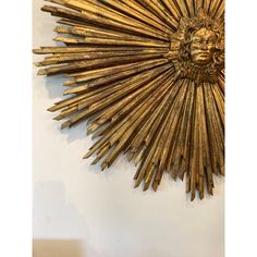 a gold sunburst is hanging on the wall