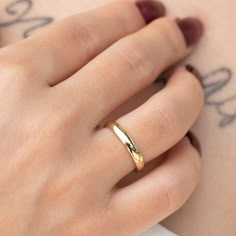 a woman's hand with a gold ring on top of her arm and the word love written in cursive writing