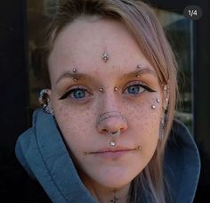 a woman with piercings on her face and nose