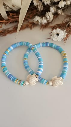 two blue and white bracelets sitting on top of a table