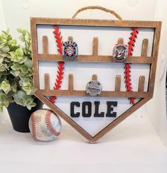 a baseball and ball are on display in front of a wooden sign that says cole