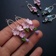 small pink and blue flowers are being held in the palm of someone's hand