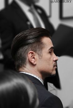 a man in a suit and tie looking off into the distance