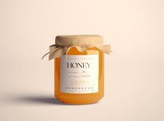 a jar of honey with a brown bow around the top on a white background,