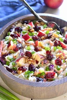 a wooden bowl filled with fruit and nuts