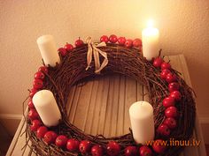 a wreath with candles and cherries on a table