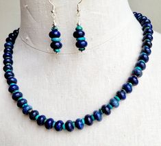 Make a statement in this one of a kind lapis lazuli and Mexican blue turquoise stone necklace set.  Strung on wire, the assorted lapis stones are polished donut beads and the turquoise stones are flat disc beads. The necklace is finished with stainless steel chain and a lobster clasp. The necklace measures 20 inches long. Matching beaded earrings are strung on 925 silver ear wires. Blue Chrysocolla Beaded Necklaces With Natural Stones, Blue Beaded Chrysocolla Necklaces With Natural Stones, Turquoise Lapis Lazuli Beaded Jewelry, Handmade Blue Chrysocolla Beaded Necklaces, Turquoise Lapis Lazuli Gemstone Beads Jewelry, Blue Chrysocolla Gemstone Beaded Necklaces, Blue Chrysocolla Jewelry With Natural Stones, Blue Lapis Lazuli Beaded Necklaces, Blue Lapis Lazuli Necklace With Colorful Beads