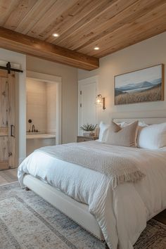 a large white bed sitting in a bedroom next to a wooden ceiling mounted light fixture